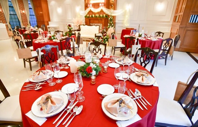 赤いテーブルクロスがかけられた円卓。その中央には緑と赤の装花が置かれている