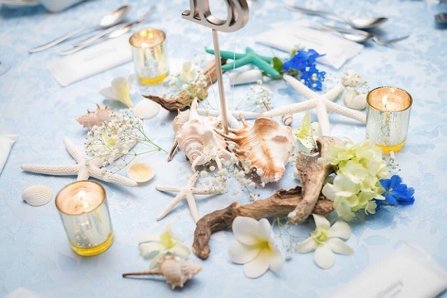 ヒトデや貝殻、流木、プルメリアなどが無造作に飾られたテーブルコーディネート
