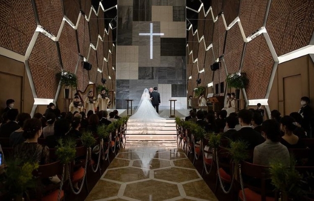 ヘキサゴンモチーフのチャペルで結婚式を挙げる新郎新婦