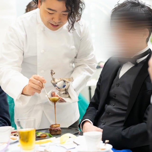 シェフの格好をした新郎が料理の仕上げをする様子