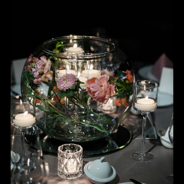 花とキャンドルを入れたガラスのボウル