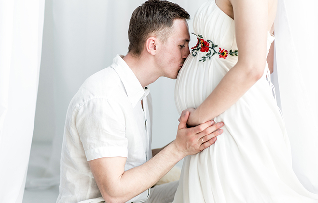 妊婦のお腹にキスをする男性