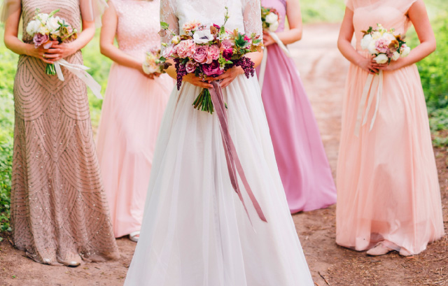 それぞれ違うピンク系の衣裳を着たブライズメイドと花嫁