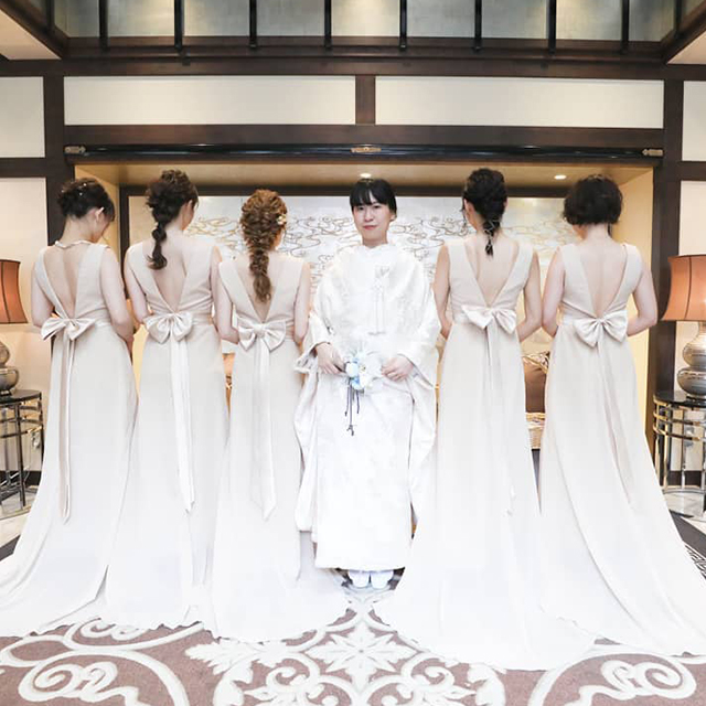 白無垢の花嫁を囲む、ドレス姿のブライズメイド 
