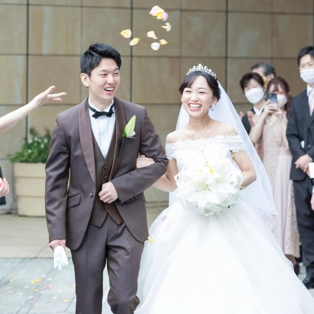 結婚式場から笑顔で退場する新郎新婦