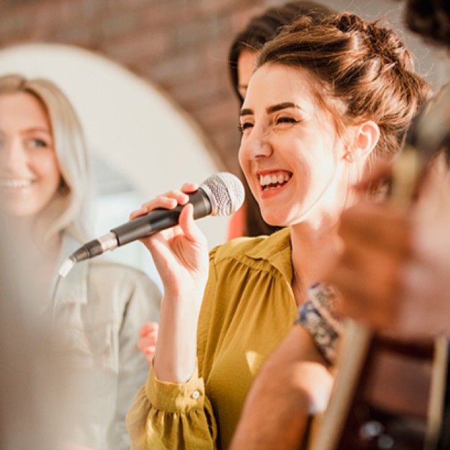 マイクを持って歌う女性