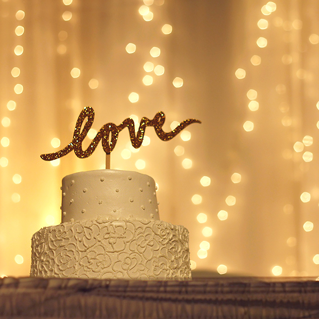 loveのトッパーが乗ったウェディングケーキと電球の装飾
