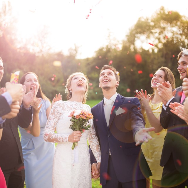 空を見上げる新郎新婦と拍手するゲストたち