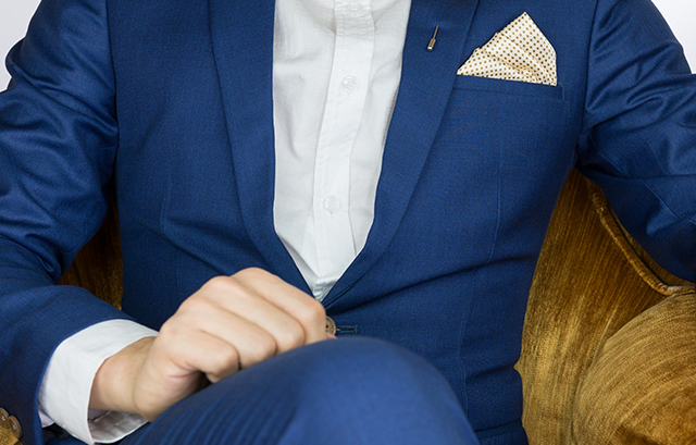 ネクタイを着けず、ポケットチーフをアクセントにしたスーツ姿の男性