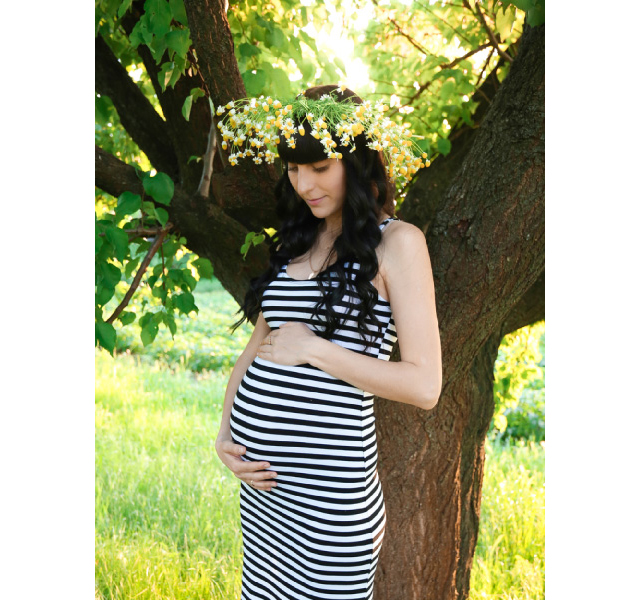 1本の木の前に立つ妊婦