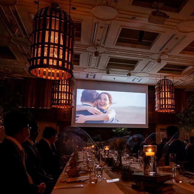 会場スクリーンに映された抱き合う新郎新婦