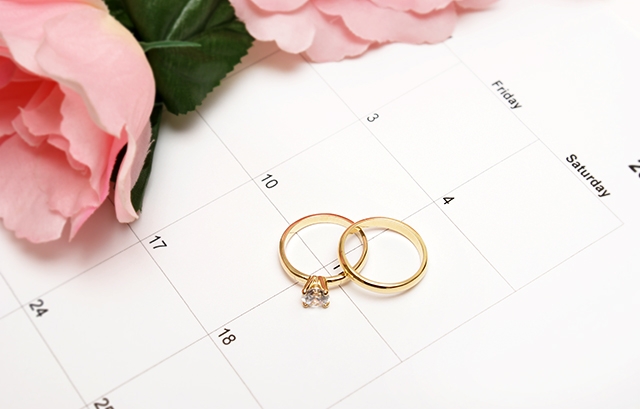 結婚指輪と婚約指輪が上に置かれたカレンダー