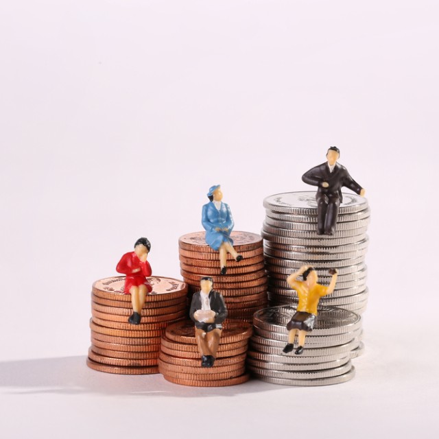 コインに腰掛けるミニチュアの人形