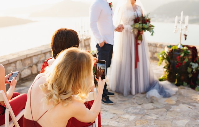 新郎新婦の様子をスマートフォンで撮影する人