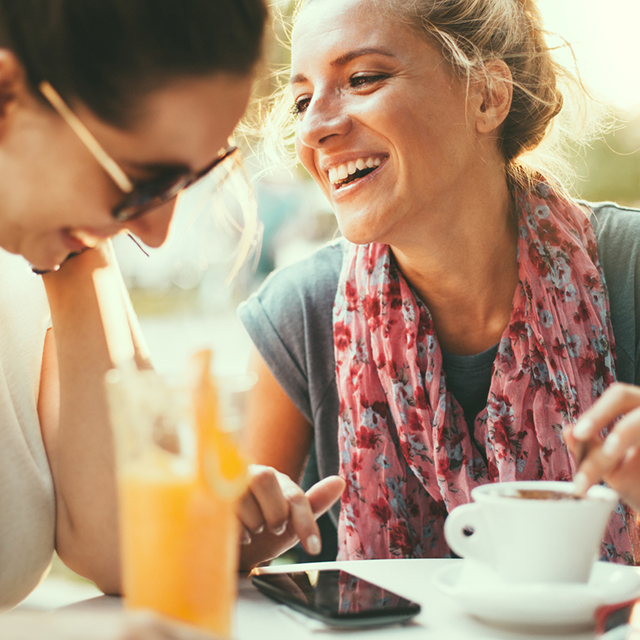 カフェで友人と談笑する女性
