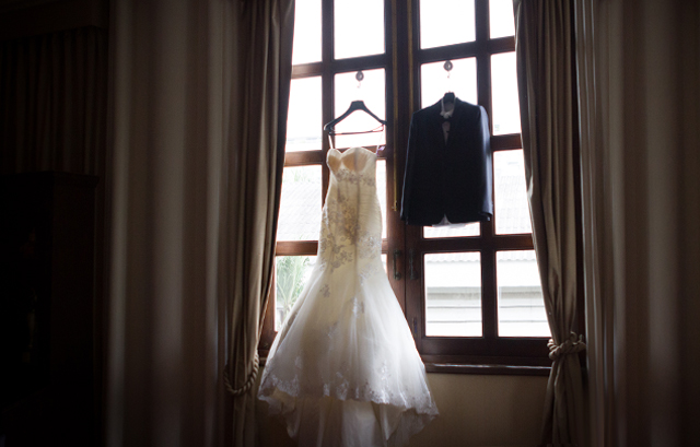 窓にかけられたウェディングドレスとタキシード