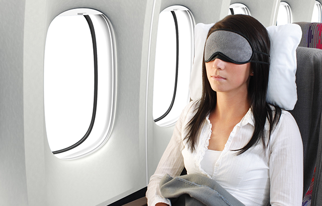 飛行機でアイマスクをしている女性