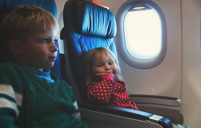 飛行機の座席に座るふたりの子供