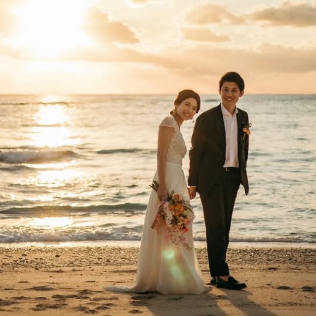 夕暮れのビーチにいる新郎新婦