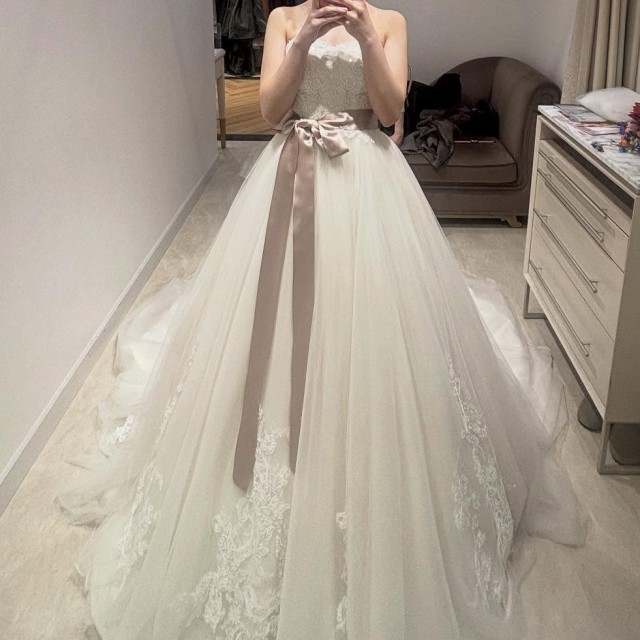 ピンクのサッシュベルトを巻いた花嫁