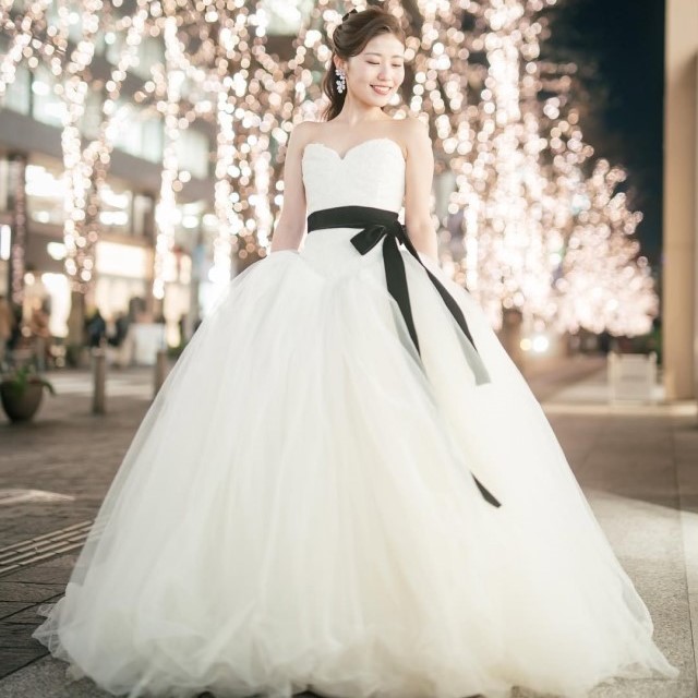 ウェストを黒いリボンで結んだドレスを着る花嫁