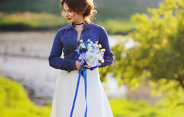 ウェディングドレスに丈の短いデニムジャケットを羽織った花嫁