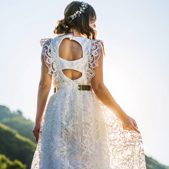 レース素材が重なり、背中の露出が個性的なドレスを着た花嫁の後ろ姿