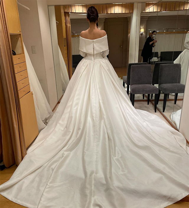 シルクの光沢が美しいオフショルダーのドレスを着た花嫁の後ろ姿