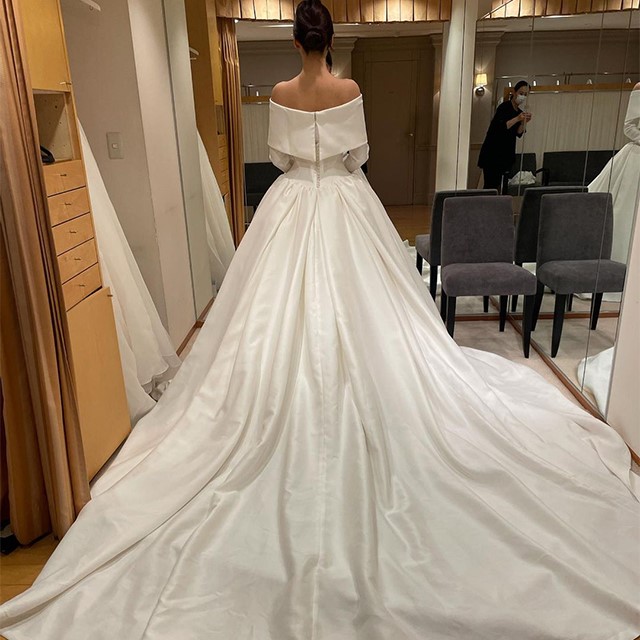 シルクの光沢が美しいオフショルダーのドレスを着た花嫁の後ろ姿