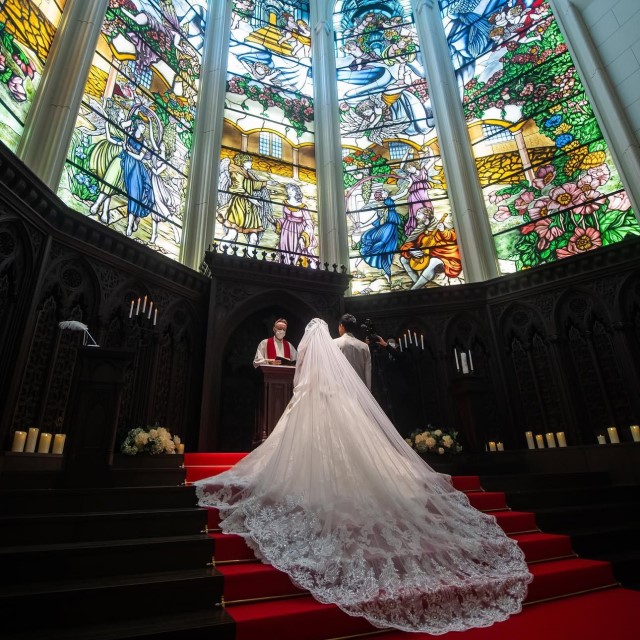 赤いバージンロードとウェディングドレスの女性