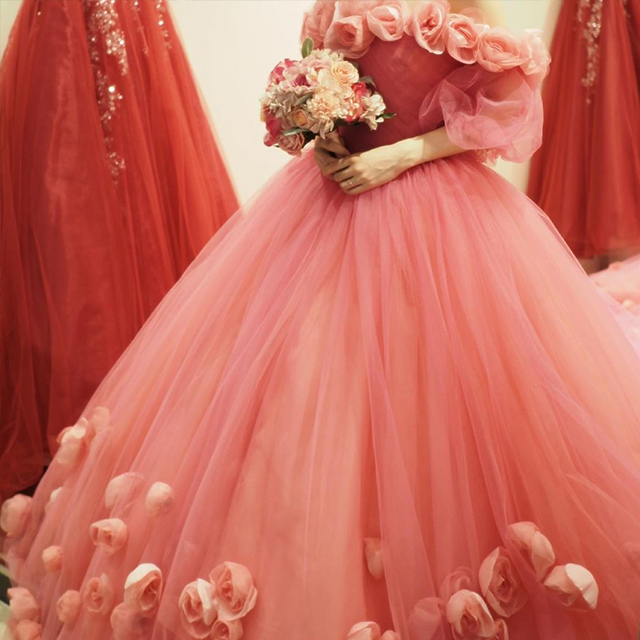 花モチーフのコーラルピンクのドレスを着た女性