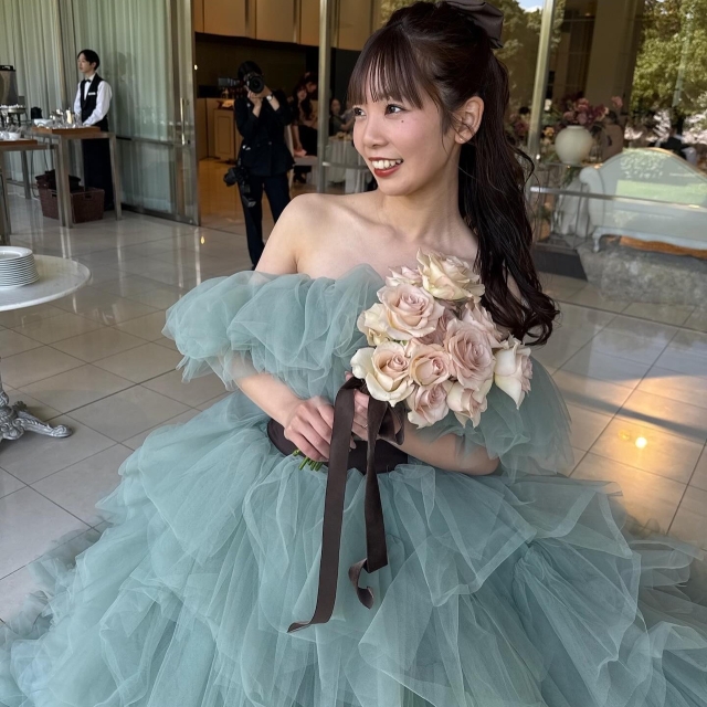 ホワイトとペールピンクのブーケを持ったくすみブルードレスの花嫁