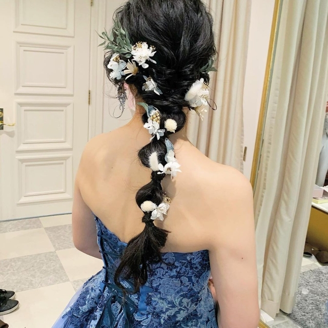 フラワーモチーフの髪飾りをつけたブルードレスの花嫁