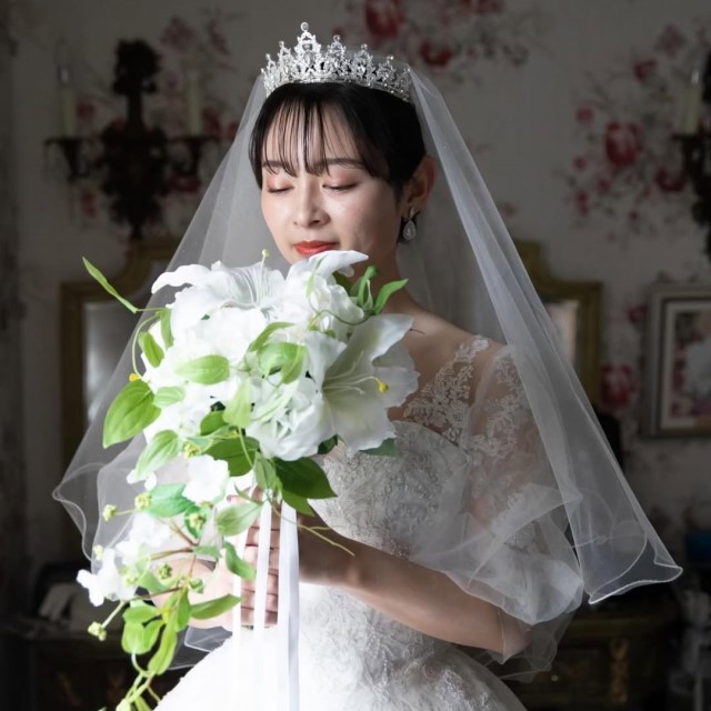 ブーケを持ってショートベールをつけた新婦