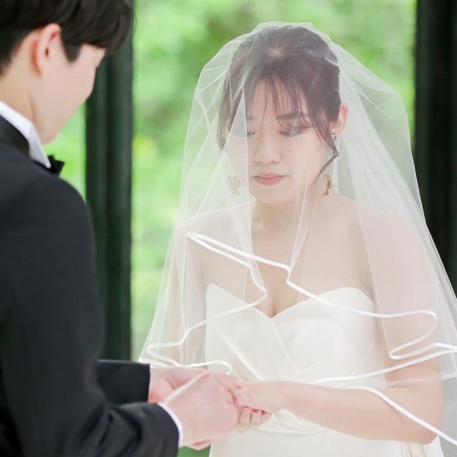 パイピングベールをつけて指輪交換する新婦