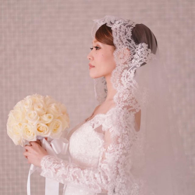 レースのあしらわれたマリアベールをつけた女性
