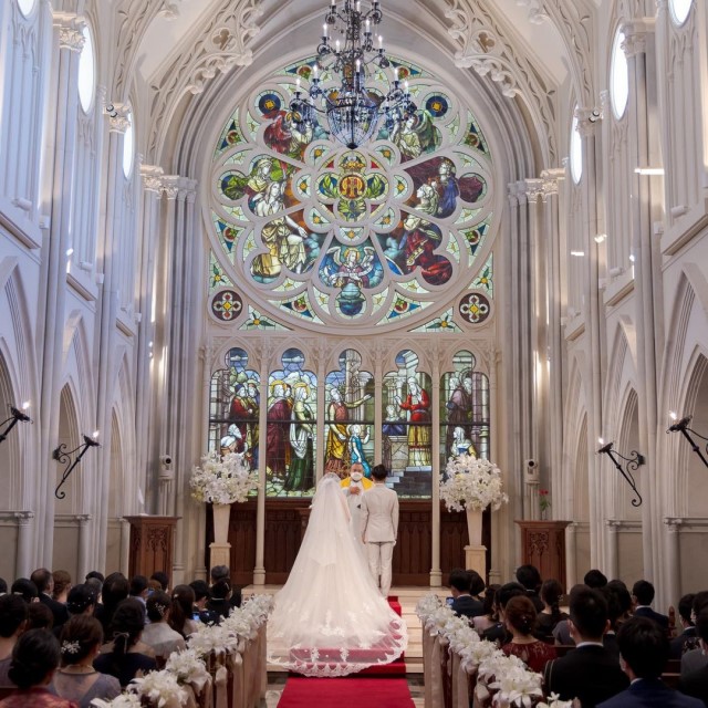 ロングベールをつけてチャペルのバージンロードに立つ新婦