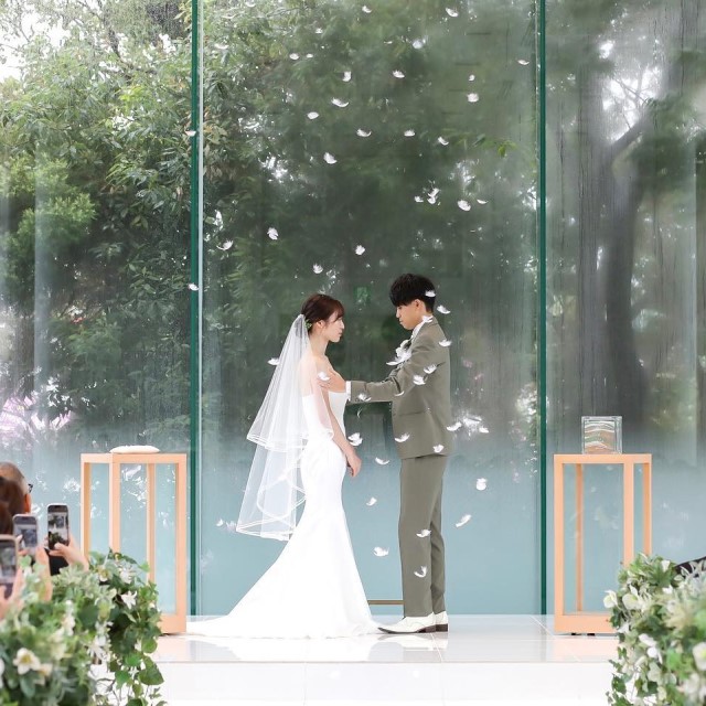 ミディアムベールをつけて新郎と向かい合う花嫁