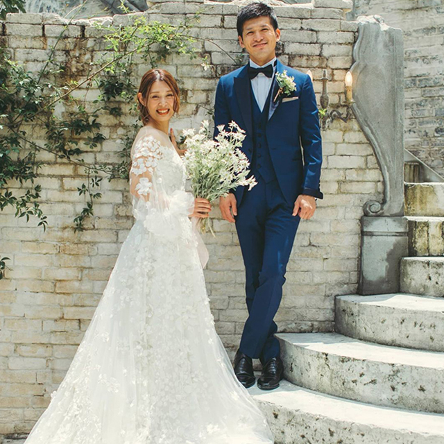 青いタキシードを着た新郎とドレス姿の新婦