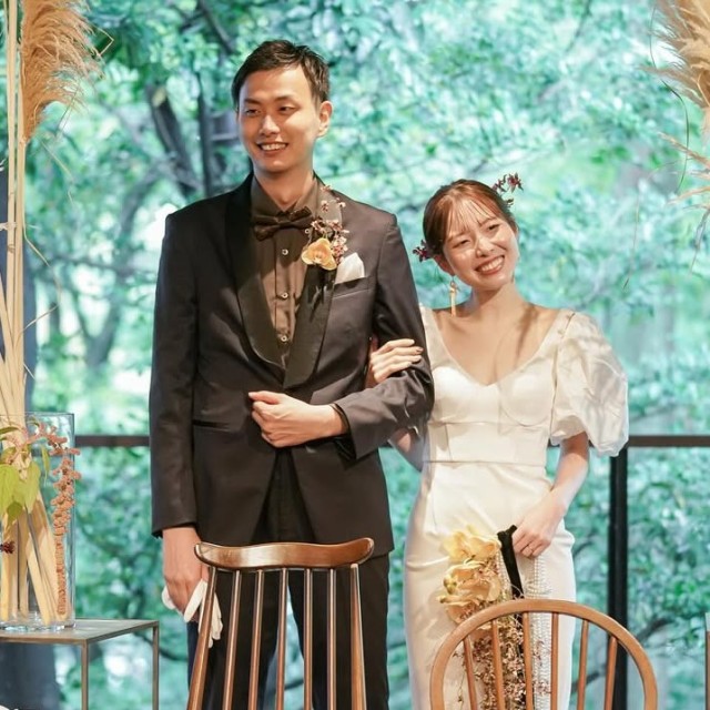 ドライフラワーのブーケを持った新婦とブートニアをつけた新郎