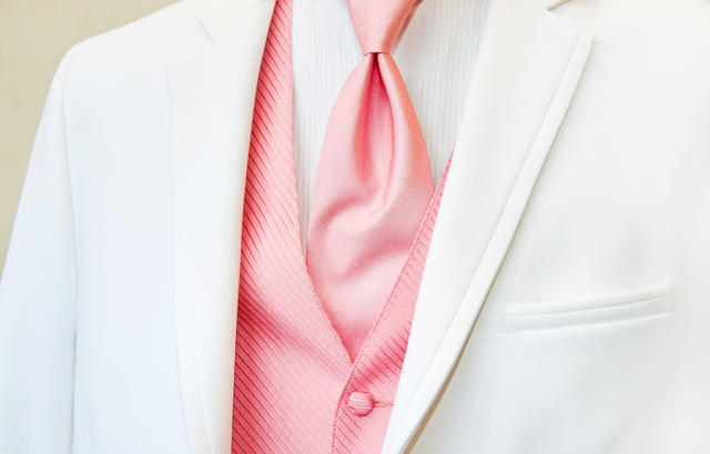 ピンクのネクタイとベストと白いタキシードの着用例