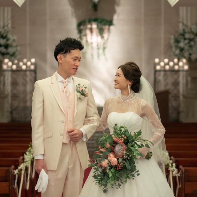 アイボリーのタキシードの新郎とドレス姿の新婦