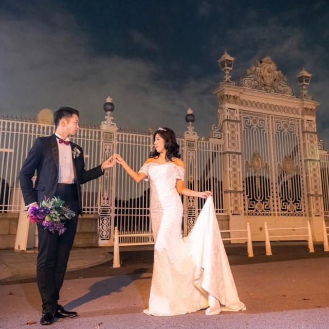 ポーズをとる黒いタキシードを着た新郎とドレス姿の新婦