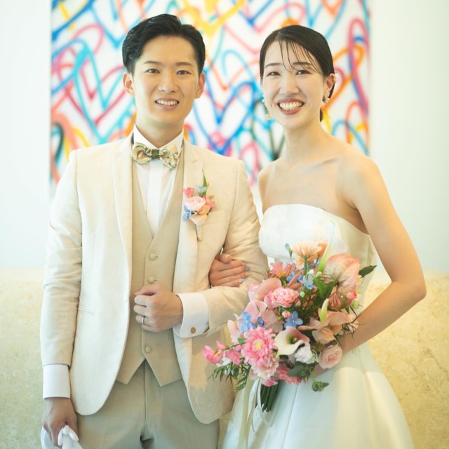 アイボリーのタキシードを着た新郎とドレス姿の新婦
