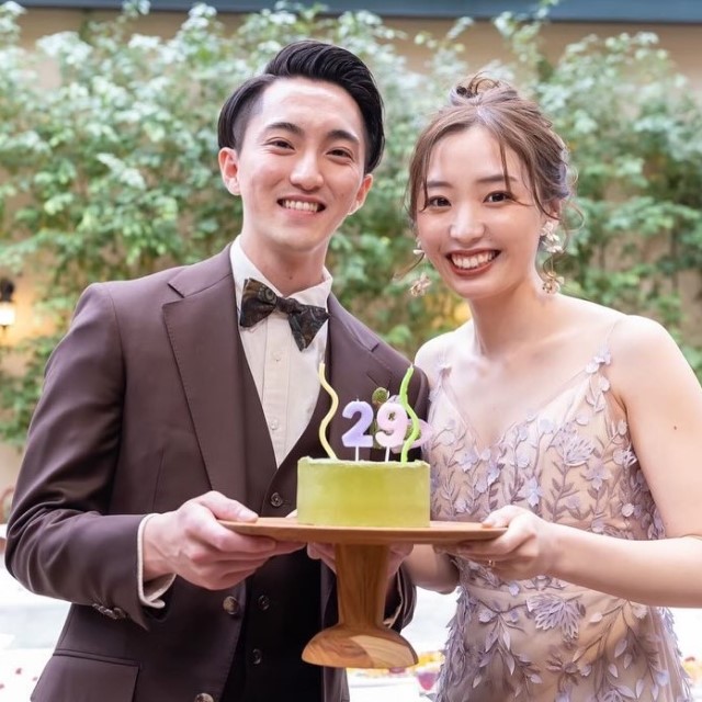 ワインレッドの衣裳を着た新郎とドレス姿の新婦