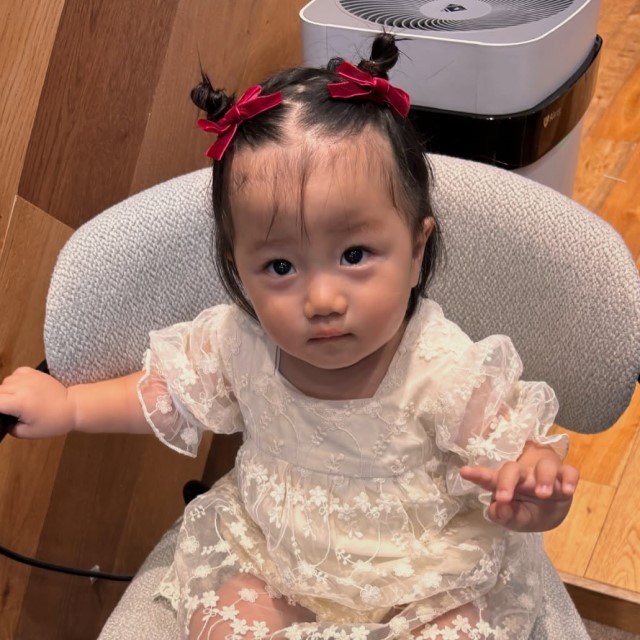 頭の左右の高い位置で小さなお団子ヘアをした子ども