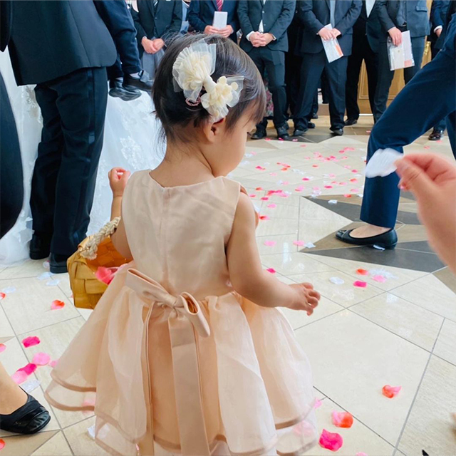 頭の右サイドに大きなリボンのヘアアクセサリーを付けた女の子