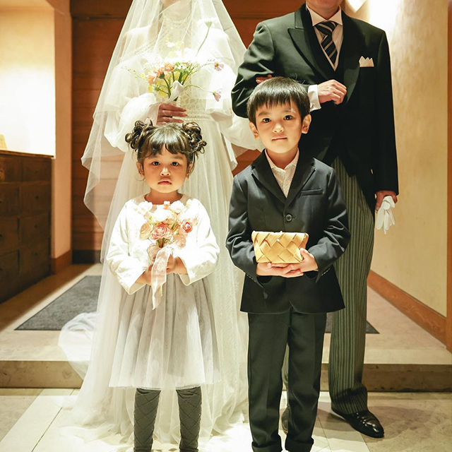 左右でふんわりとしたお団子ヘアにした女の子が男の子と一緒に並んでいる様子