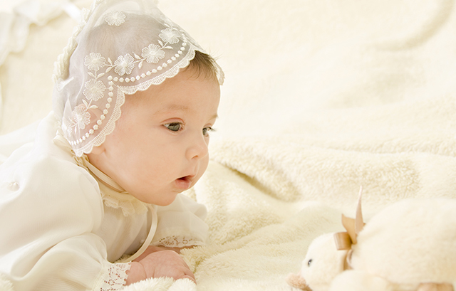 白いベビードレスを着た赤ちゃん