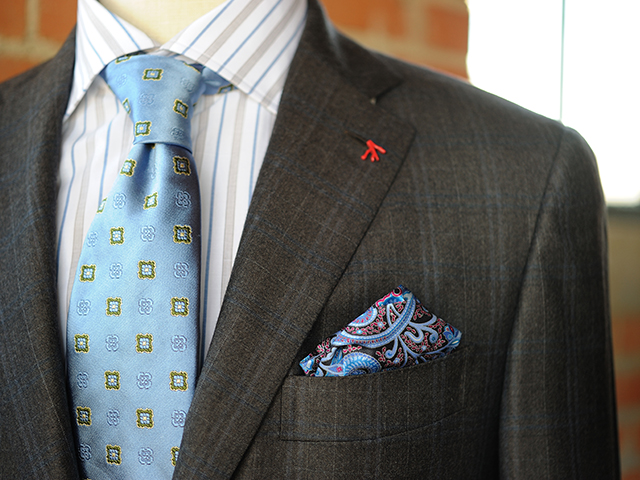 チェックのスーツにストライプのシャツ、柄物のネクタイとポケットチーフのコーディネート